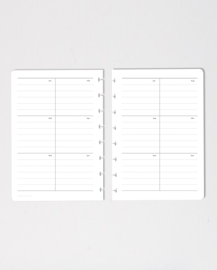 Set of erasable yearly calendar notebook pages on grey background